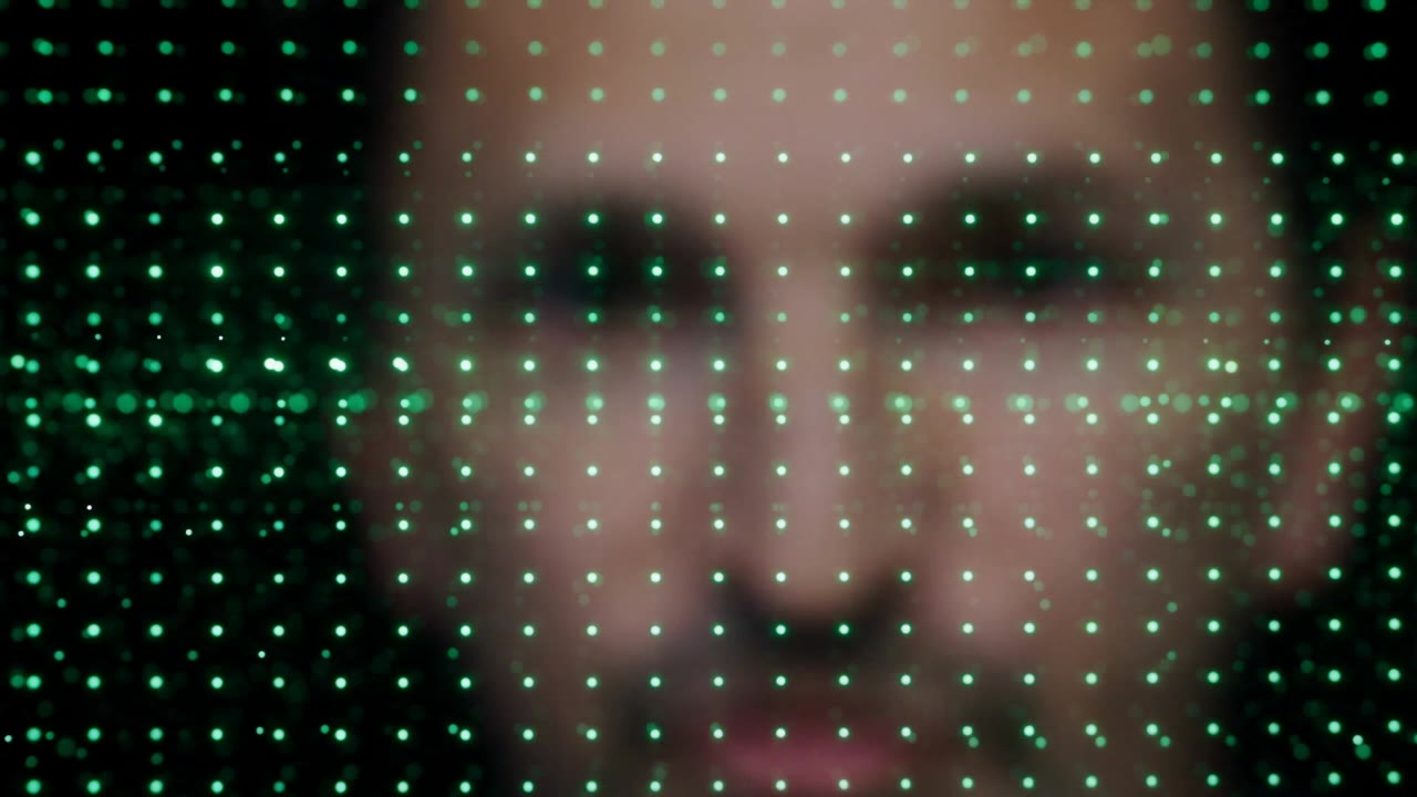 A regular grid of green glowing droplets in front of a blurred face.