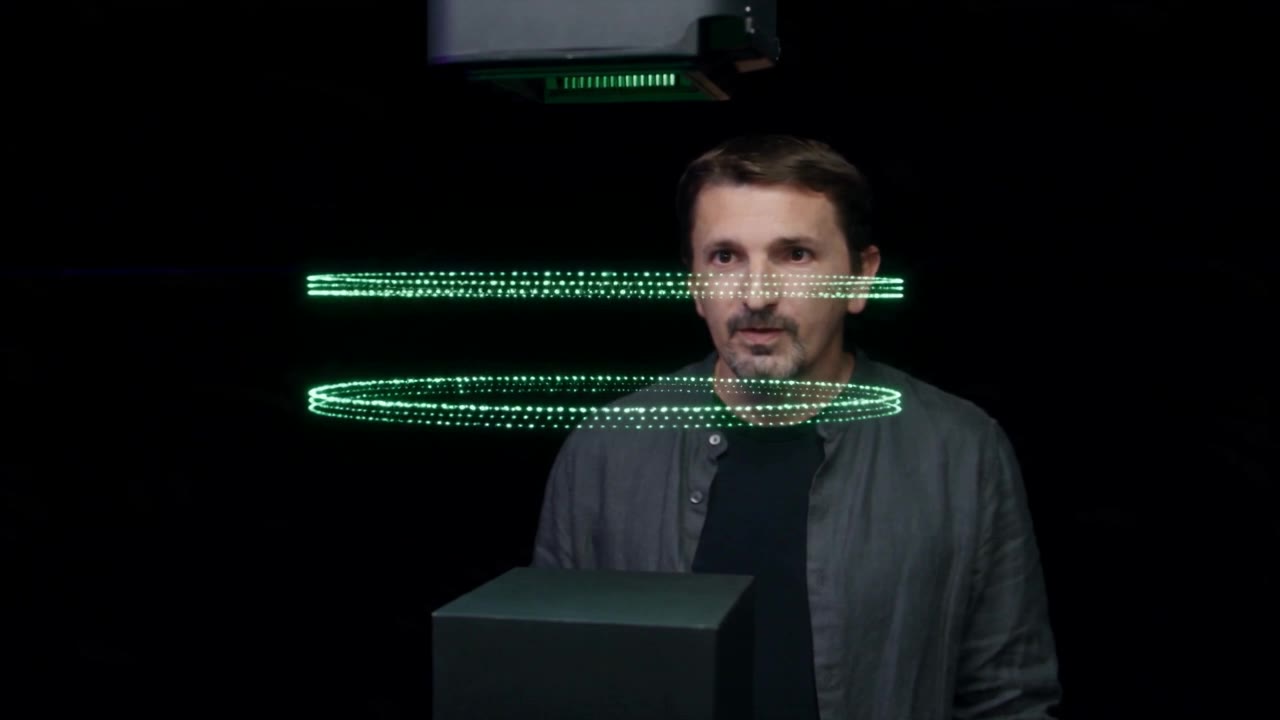 Two rings of green light points floating between a dark head and a dark base.